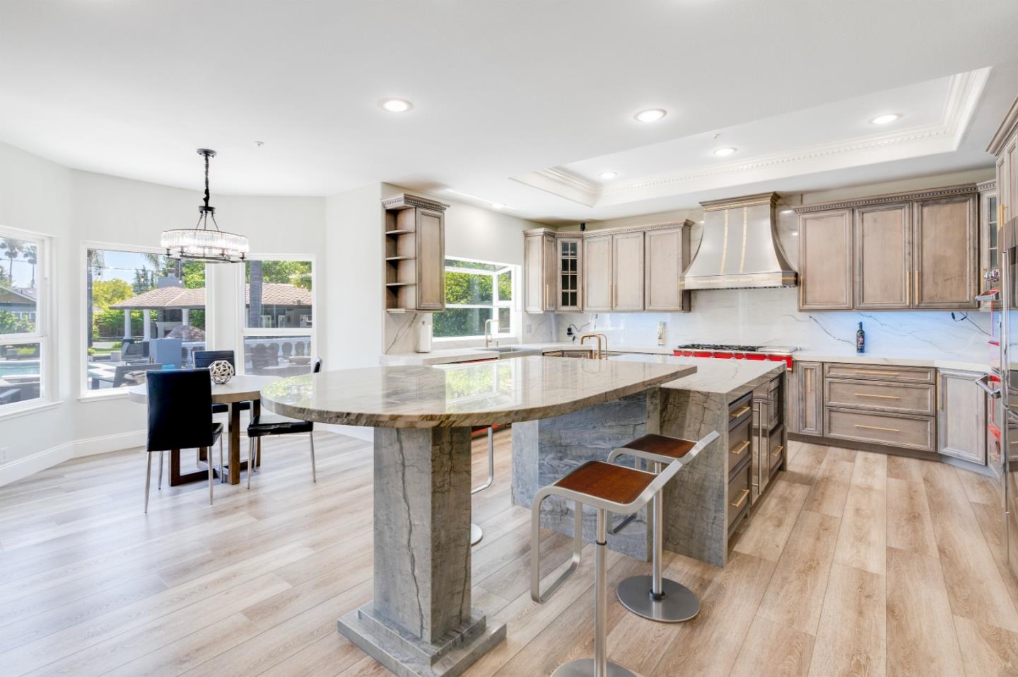 1940 Pear Drive Morgan Hill, CA 95037 - Photo 8 of 36 a kitchen with granite countertop a stove a sink a dining table and chairs with wooden floor