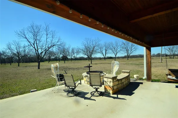 a view of a swimming pool and lounge chairs in back yard of the house