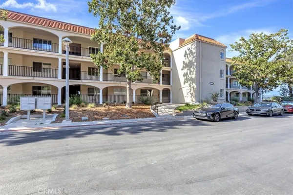a view of a building with cars parked in front of it