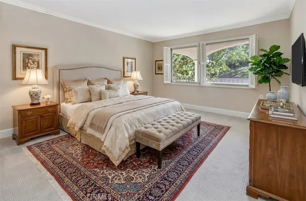 a bedroom with a bed a rug and a window