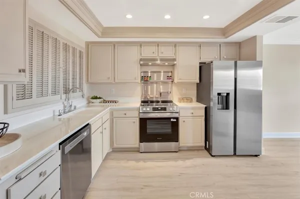 a kitchen with stainless steel appliances a refrigerator sink and cabinets