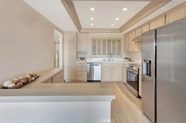 a kitchen with white cabinets and stainless steel appliances