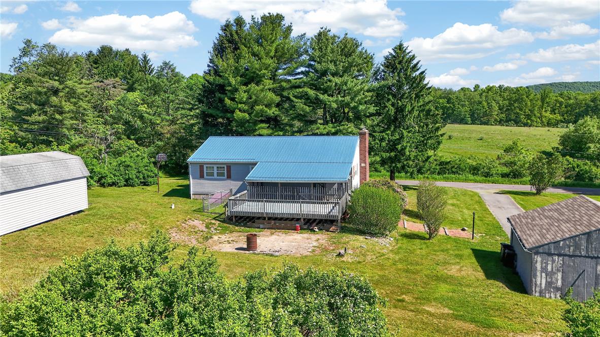 62 Stoney Road Tamaqua, PA 18252 - Photo 26 of 61 Perched amidst a verdant landscape, this inviting home features a broad deck and a bright blue metal roof.