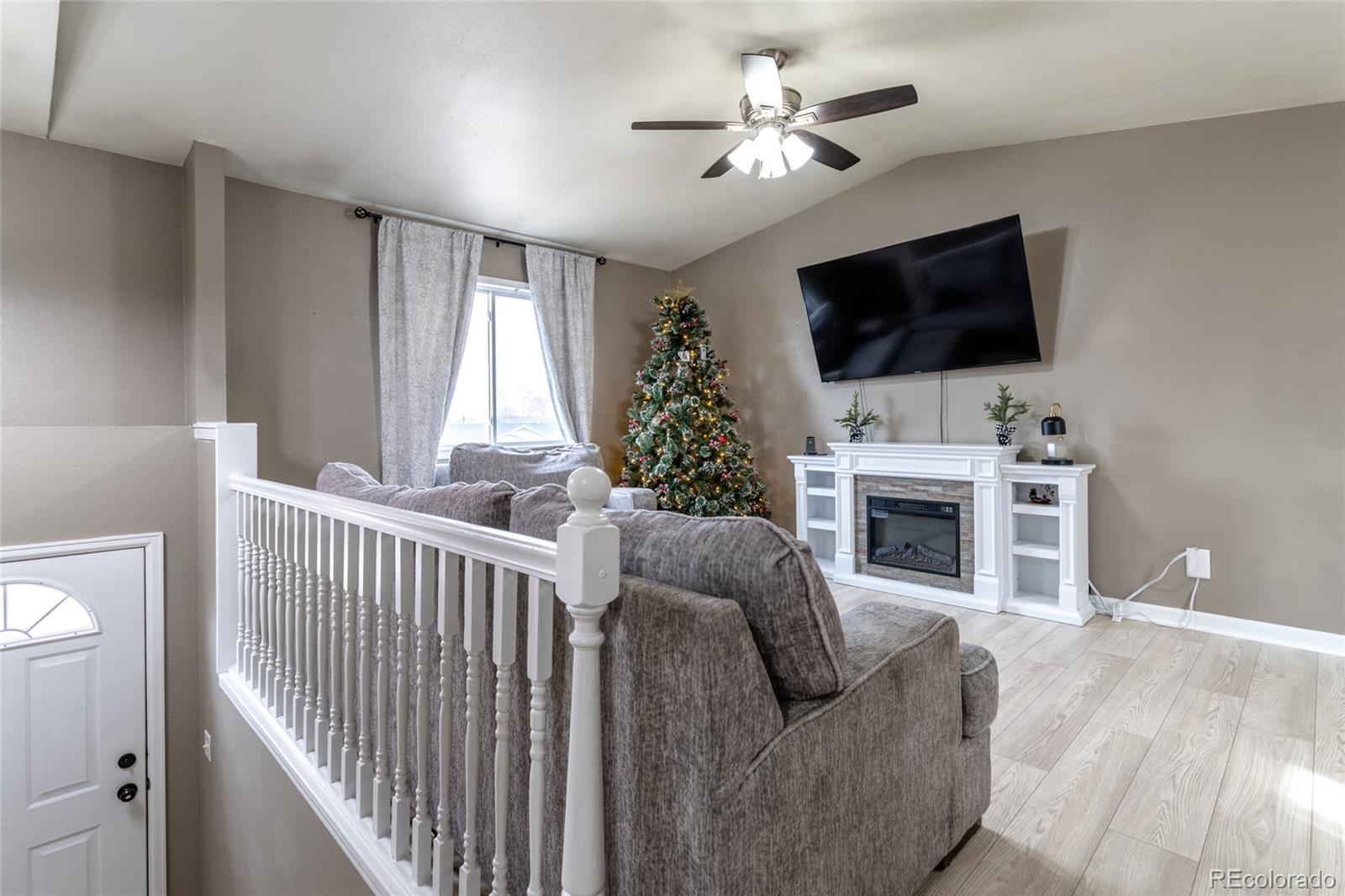 3192 West 3rd Street Road Greeley, CO 80631 - Photo 3 of 31 a living room with furniture a flat screen tv and a fireplace