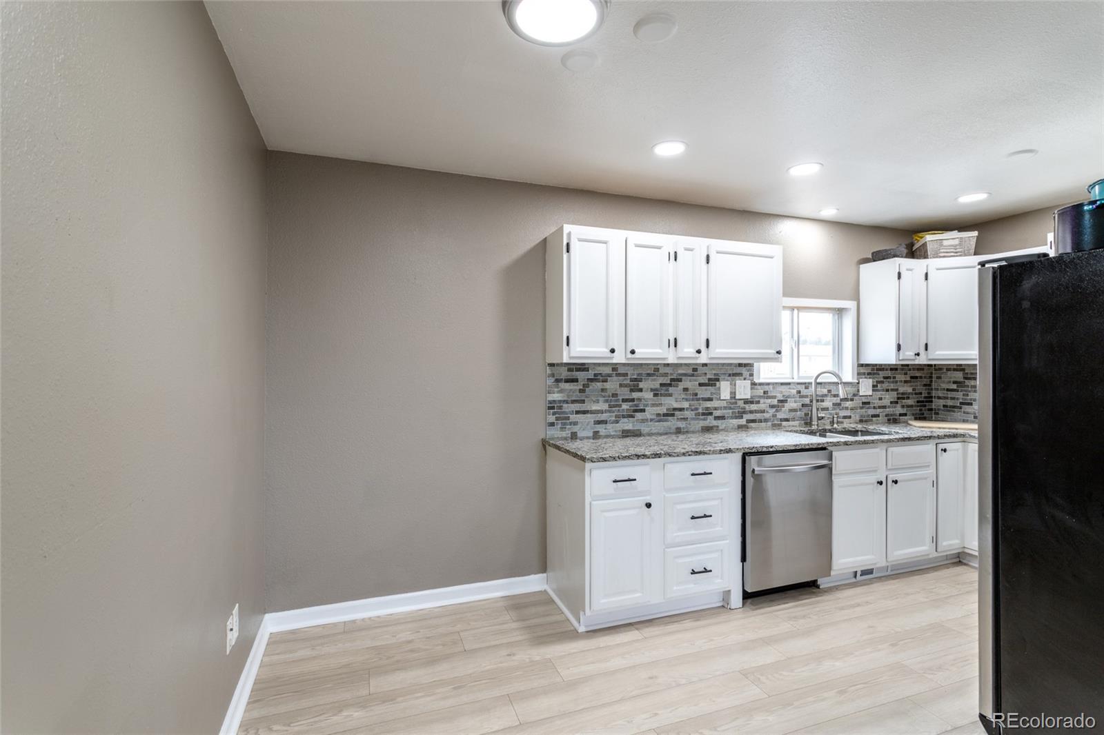 3192 West 3rd Street Road Greeley, CO 80631 - Photo 8 of 31 a kitchen with granite countertop white cabinets and refrigerator