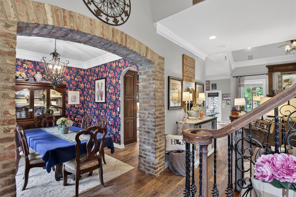 11868 Timber Ridge Drive Keithville, LA 71047 - Photo 6 of 37 Exposed brick archway leading into a dining area featuring floral wallpaper, crown molding, and a chandelier