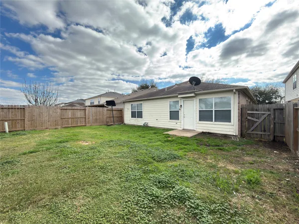 a view of a yard in front of a house with a large tree