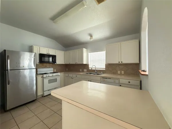 a kitchen with a refrigerator a sink and a stove