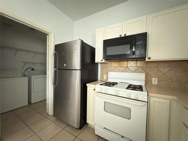a kitchen with stainless steel appliances white cabinets and a refrigerator
