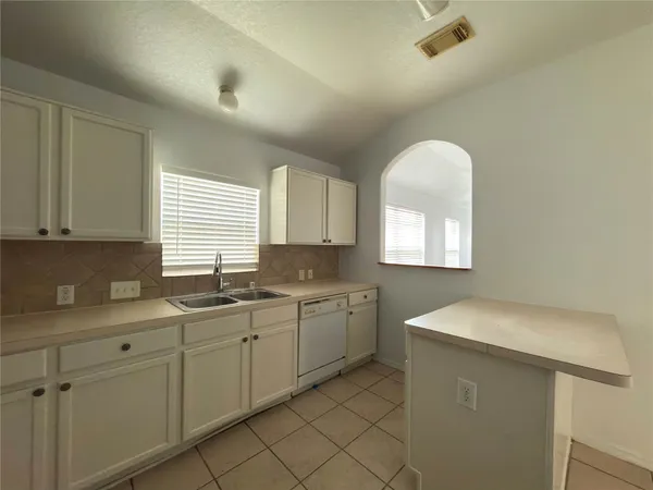 a kitchen with sink a window and cabinets