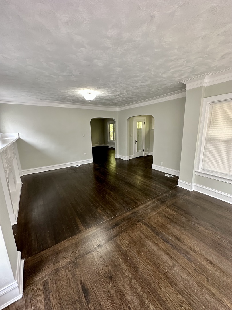 7828 South Carpenter Street Chicago, IL 60620 - Photo 3 of 18 a view of empty room with wooden floor and fan