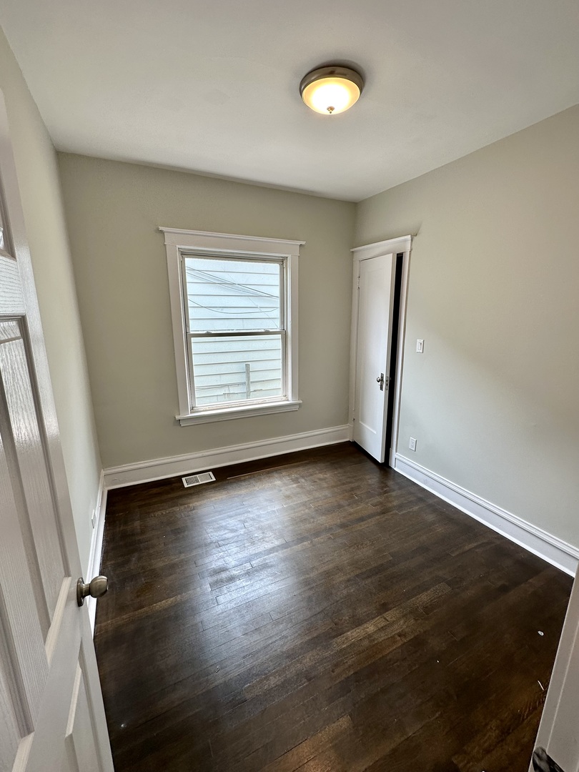 7828 South Carpenter Street Chicago, IL 60620 - Photo 7 of 18 an empty room with wooden floor and windows