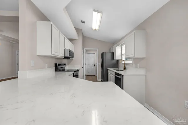 a kitchen with stainless steel appliances a stove microwave and sink