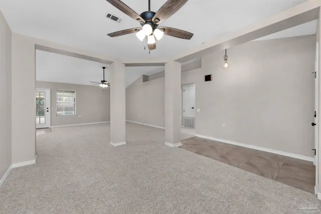 an empty room with a ceiling fan and a window