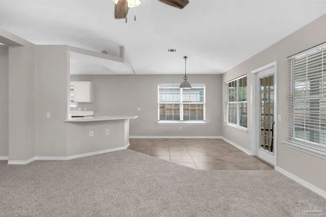 an empty room with a ceiling fan and a window