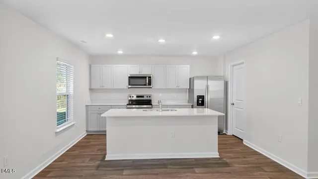 a view of kitchen with stainless steel appliances granite countertop refrigerator sink and stove