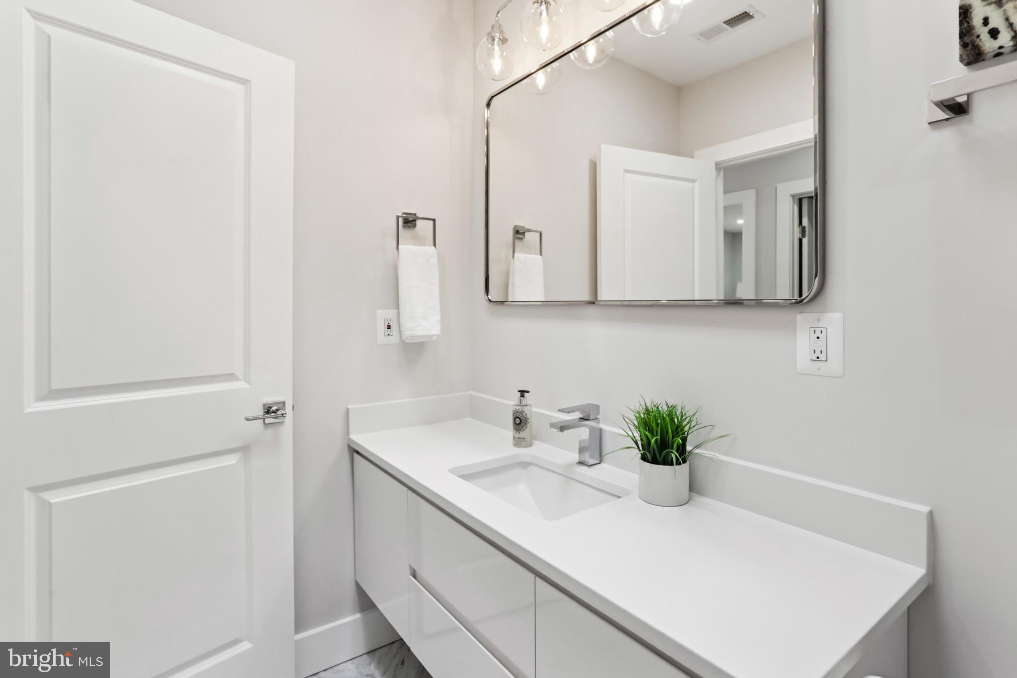 208 Webster Street Northwest Washington, DC 20011 - Photo 27 of 46 a bathroom with a sink a vanity and a mirror