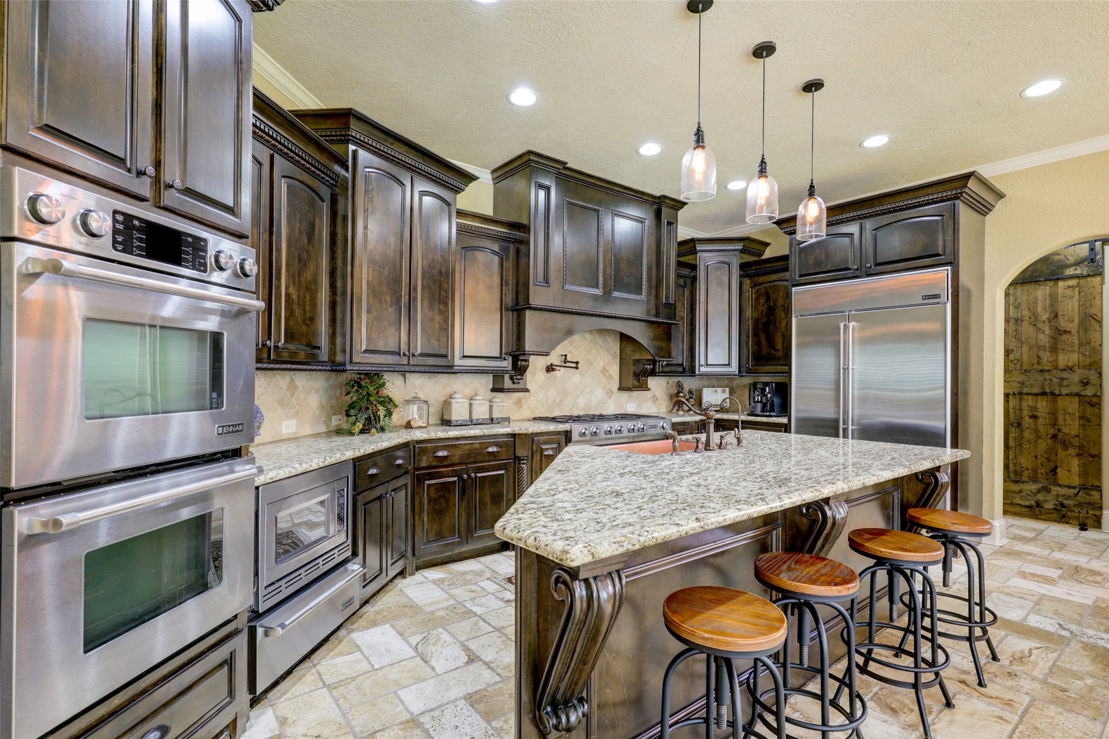 4434 Chateau Creek Way Spring, TX 77386 - Photo 14 of 34 This kitchen features custom cabinetry, new top of the line JennAir stainless steel appliances, and a large granite island with copper farmhouse sink. The space includes ample seating and an inviting atmosphere.