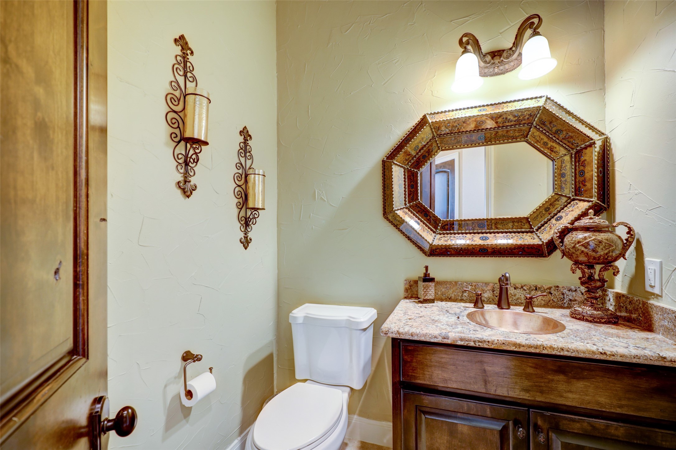 4434 Chateau Creek Way Spring, TX 77386 - Photo 21 of 34 This powder room features a unique octagonal mirror and copper sink. The warm color palette and ornate fixtures add a touch of luxury.