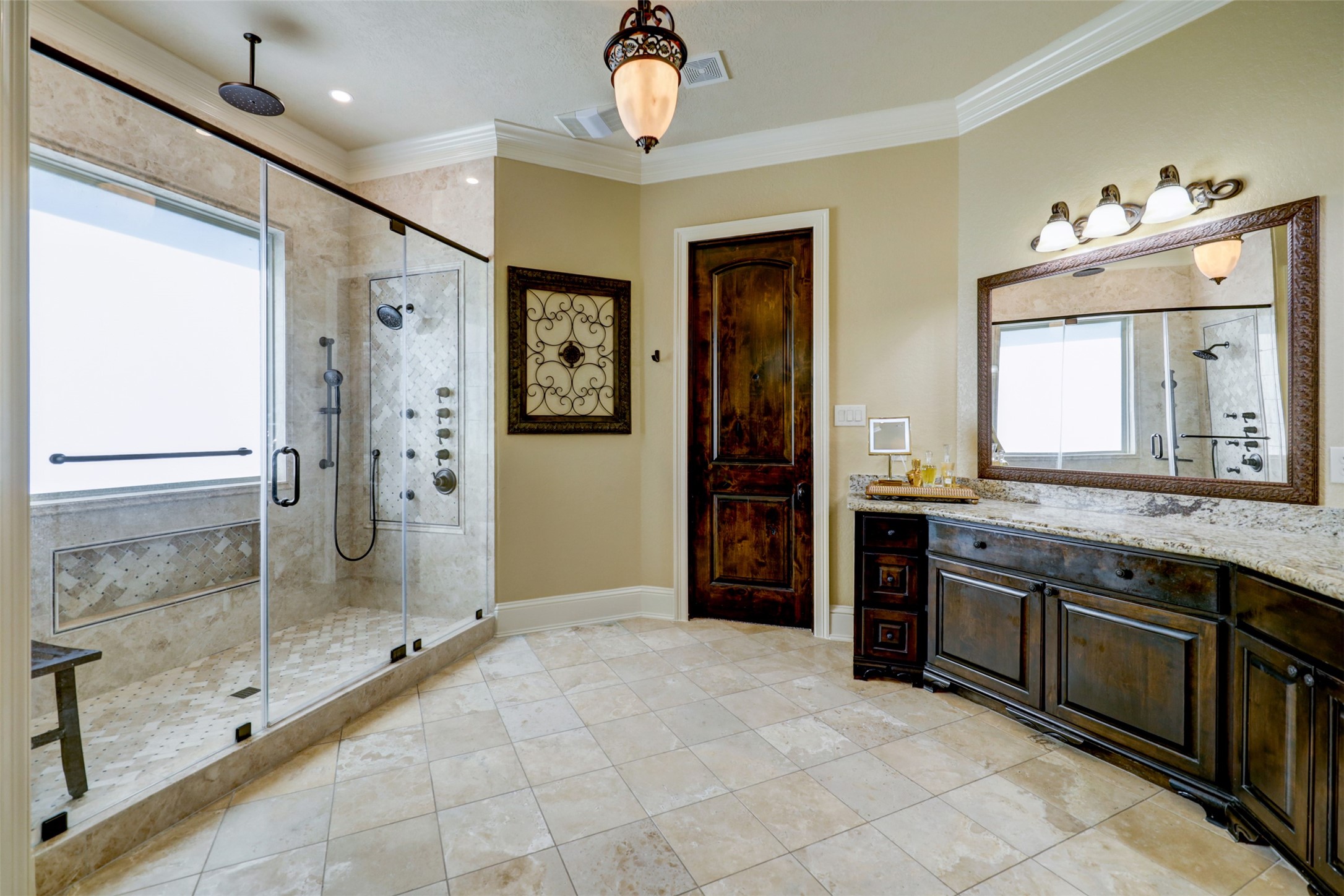 4434 Chateau Creek Way Spring, TX 77386 - Photo 24 of 34 The elegant primary ensuite featuring a large glass-enclosed shower with multiple showerheads and luxurious marble tile creating a sophisticated and comfortable space.