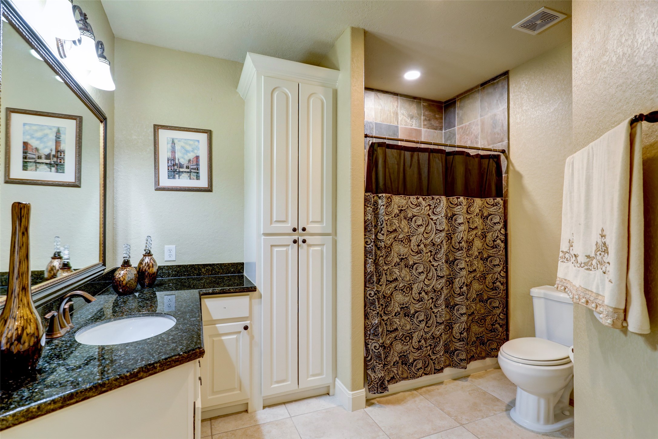 4434 Chateau Creek Way Spring, TX 77386 - Photo 30 of 34 This bathroom features elegant tile flooring, a granite countertop with a sink, and ample storage with a tall cabinet.