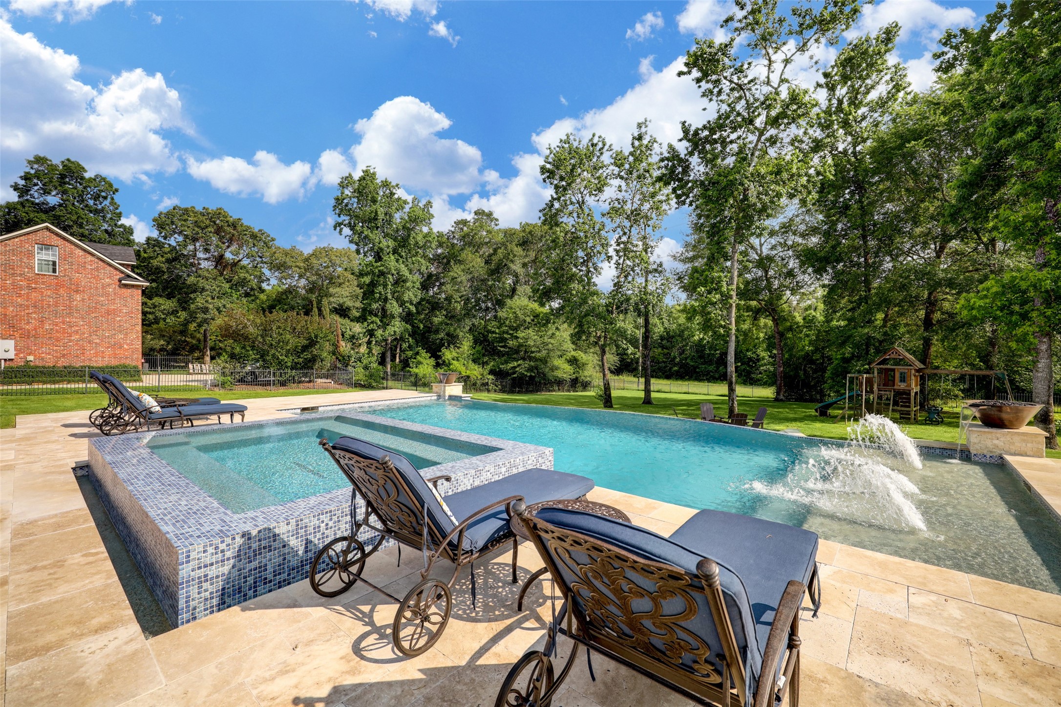 4434 Chateau Creek Way Spring, TX 77386 - Photo 6 of 34 Another view of the oversized infinity pool with plenty of stone decking for outdoor furniture. The water feature, fire-bowls, and pool lighting features are great for entertaining,