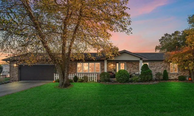 a front view of a house with a garden and yard