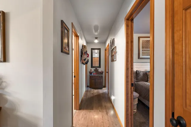 a view of a hallway with wooden floor and livingroom