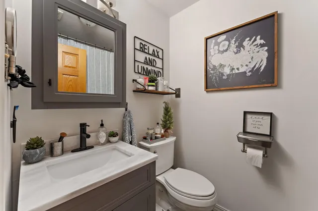 a bathroom with a toilet a sink and mirror