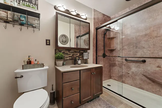 a bathroom with a toilet a sink and mirror