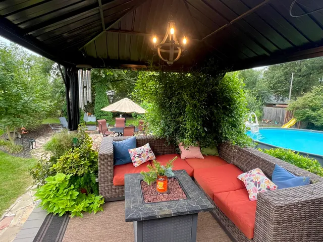 an outdoor sitting area with furniture and a garden