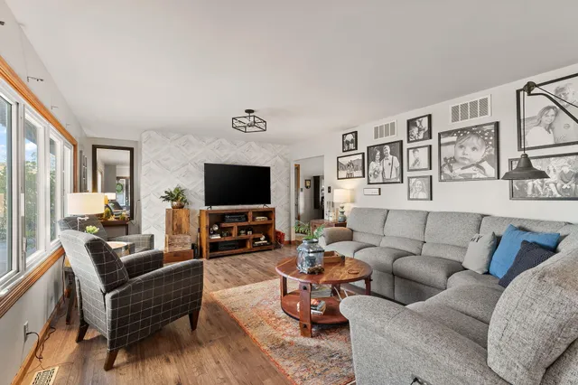 a living room with furniture wooden floor and a flat screen tv