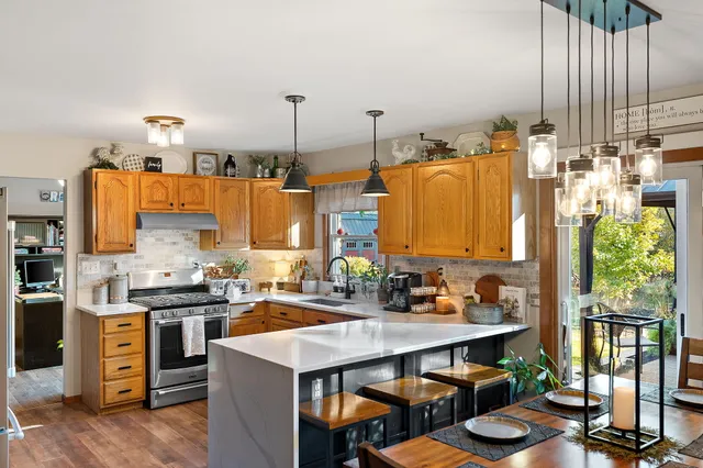 a kitchen with stainless steel appliances a stove a sink dishwasher and cabinets with wooden floor
