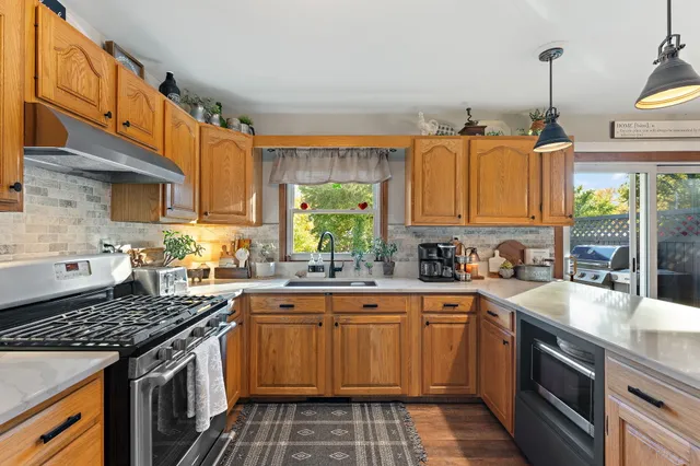 a kitchen with a sink stove top oven and cabinets