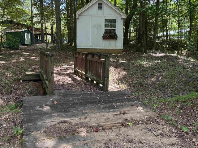 a view of a house with backyard and trees