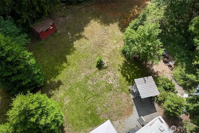an aerial view of a house with a yard and lake view