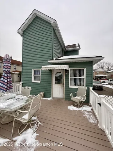 a roof deck with table and chairs and wooden floor