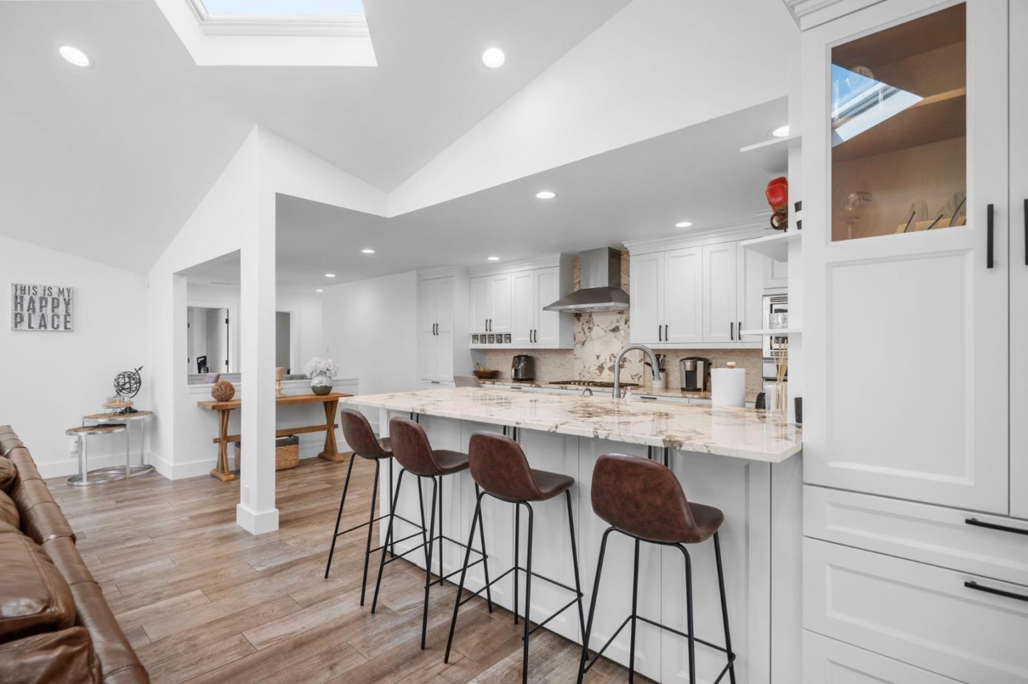 575 Darrell Road Hillsborough, CA 94010 - Photo 21 of 75 a kitchen with stainless steel appliances a dining table chairs stove and white cabinets