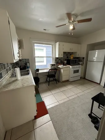 a kitchen with stainless steel appliances kitchen island granite countertop a stove a sink a dining table and chairs