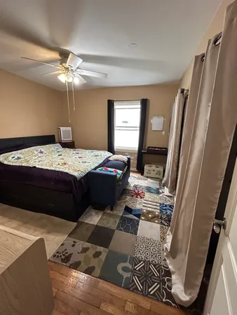 a bedroom with a bed and wooden floor