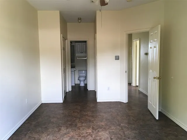 an empty room with closet and a bathroom