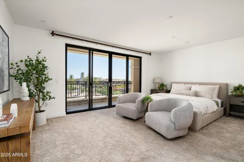 a spacious bedroom with a bed and a couch next to a window