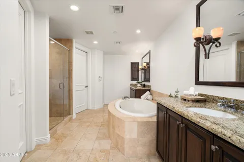 a spacious bathroom with a granite countertop sink a toilet a mirror and shower