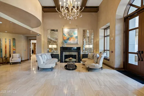 a living room with furniture a chandelier and a fireplace