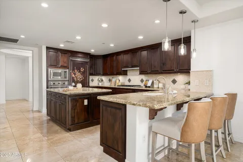 a kitchen with stainless steel appliances granite countertop a sink and a refrigerator