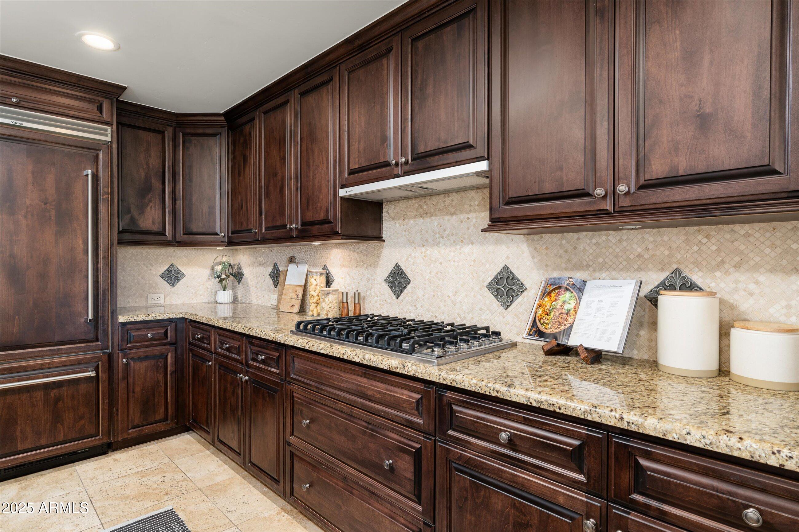 7175 East Camelback Road, Unit 510 Scottsdale, AZ 85251 - Photo 5 of 34 a kitchen with granite countertop wooden cabinets and a sink