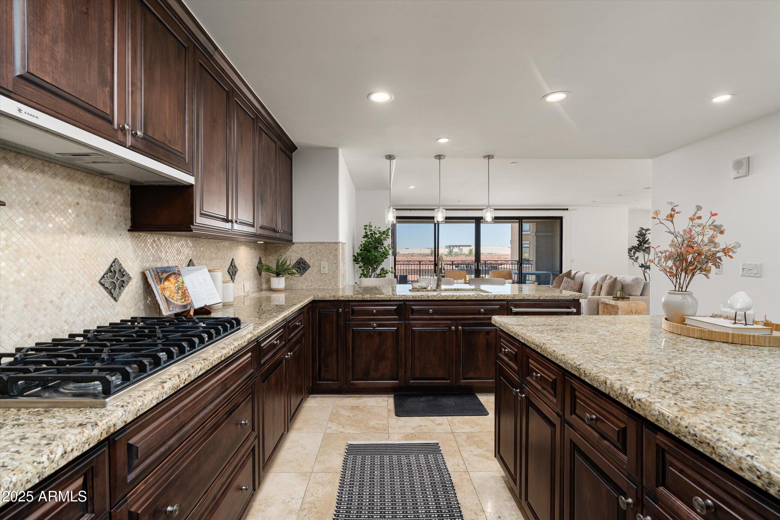 7175 East Camelback Road, Unit 510 Scottsdale, AZ 85251 - Photo 7 of 34 a kitchen with kitchen island granite countertop a sink and stove