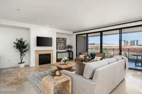 a living room with furniture large windows and a fireplace