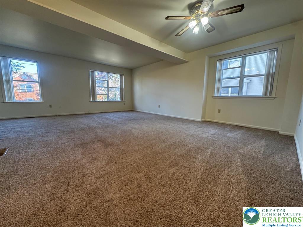 318 Mickley Road Whitehall, PA 18052 - Photo 3 of 25 an empty room with chandelier fan and windows