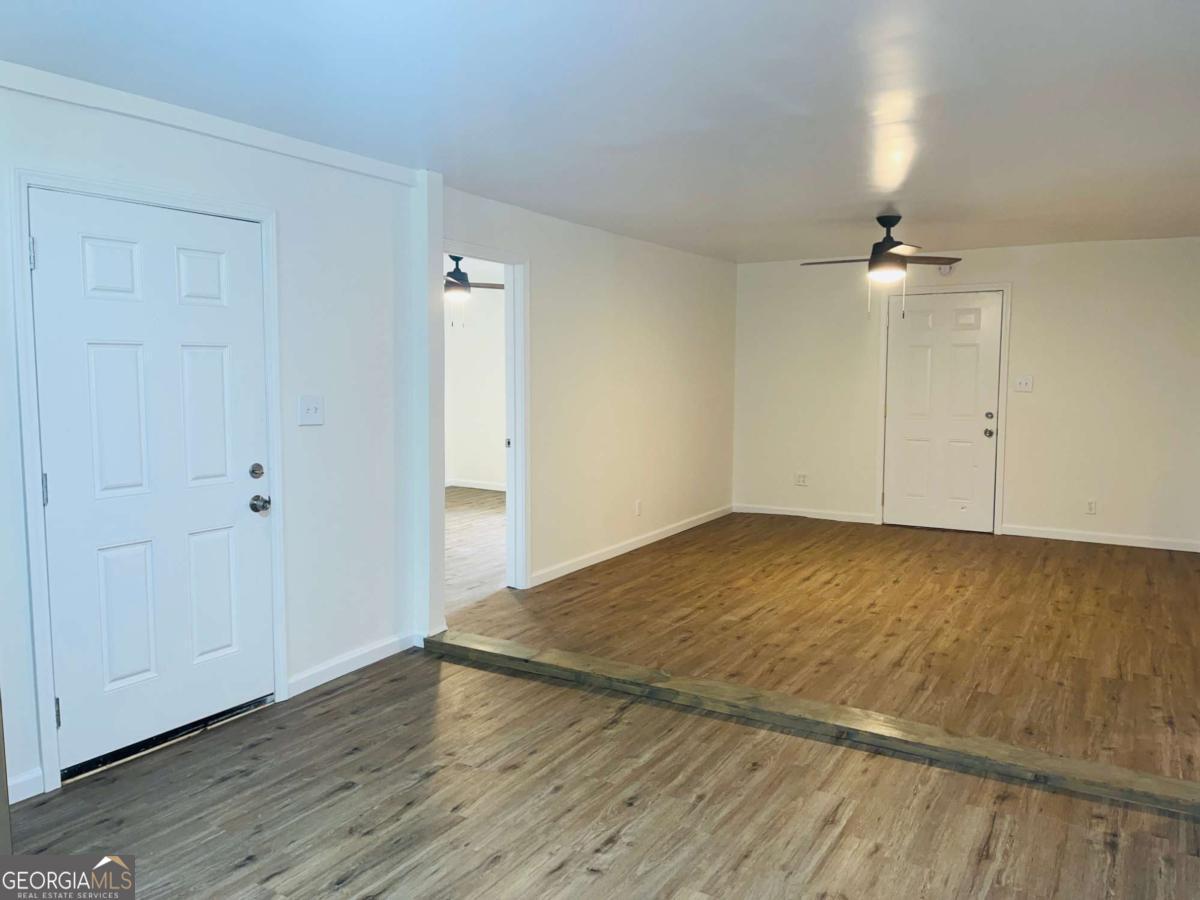 1316 Forrest Avenue LaGrange, GA 30240 - Photo 6 of 18 an empty room with wooden floor fan and windows